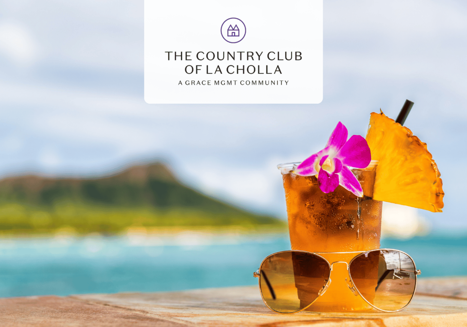 Tropical drink with a pineapple slice and orchid, paired with sunglasses on a wooden surface by the ocean, featuring a white logo card for The Country Club of LA Cholla above.