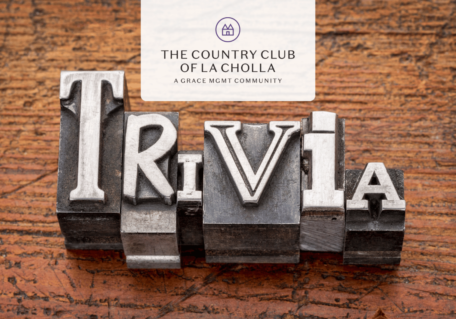 Letters formed by vintage metal type spelling 'IRVIA' on a wooden desk, with a white card featuring a logo and the text 'The Country Club of La Jolla' above.